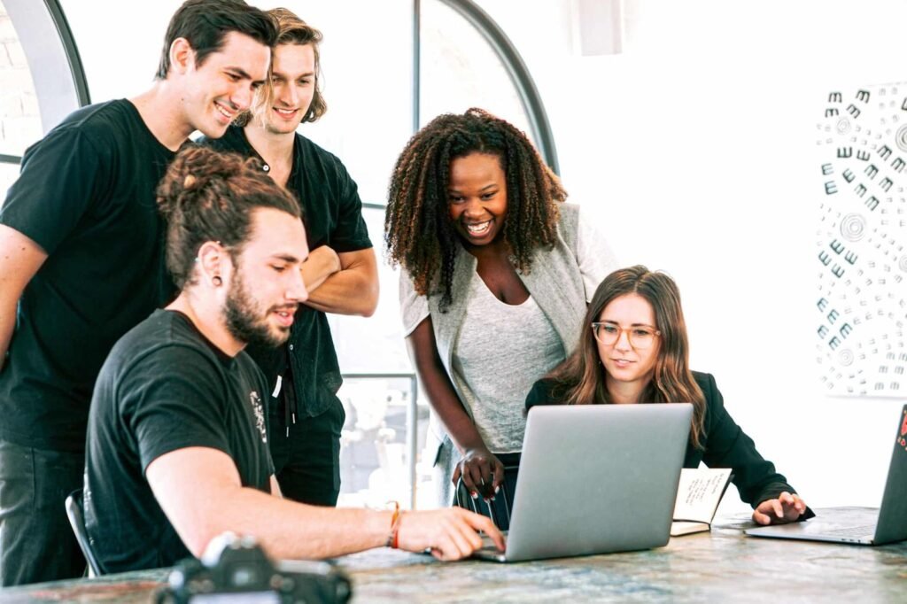 Equipe da Manáry reunida em volta de um notebook, analisando resultados de campanha